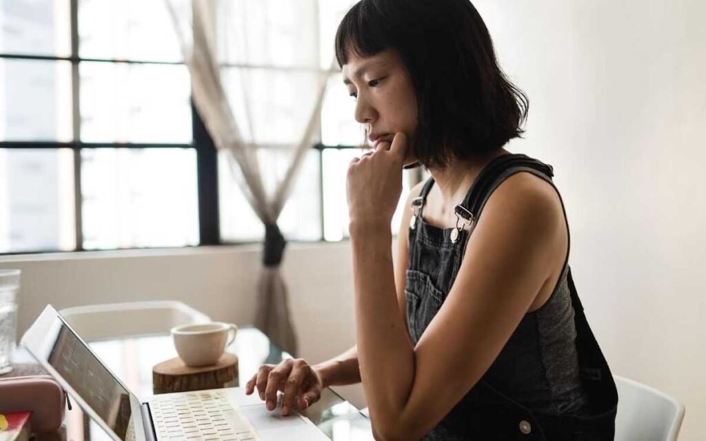 A woman sits at a desk as she works on a computer : business analytics bootcamp